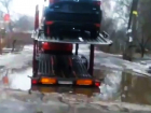 Воронежец снял на видео, как огромный автовоз с иномарками застрял в луже