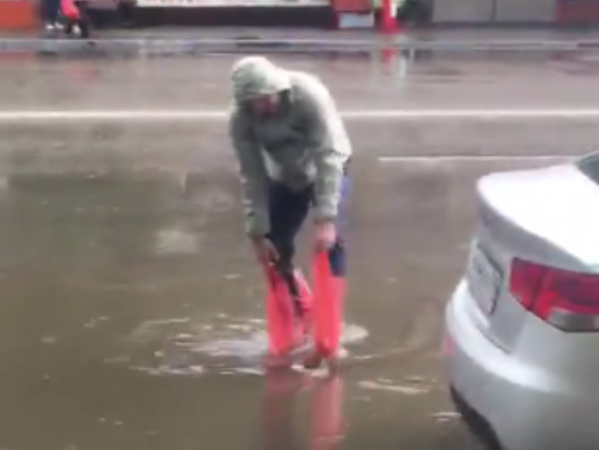Мужчина с пакетами бросил вызов потопу в Воронеже 