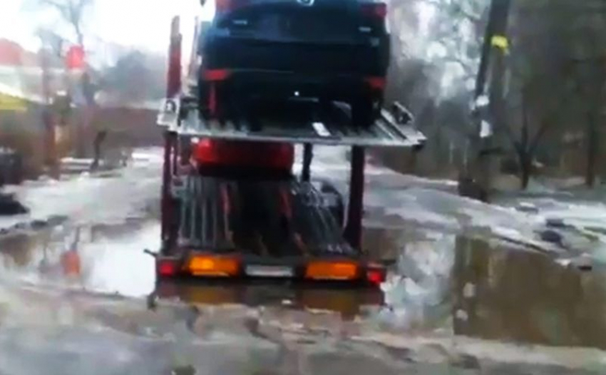 Воронежец снял на видео, как огромный автовоз с иномарками застрял в луже